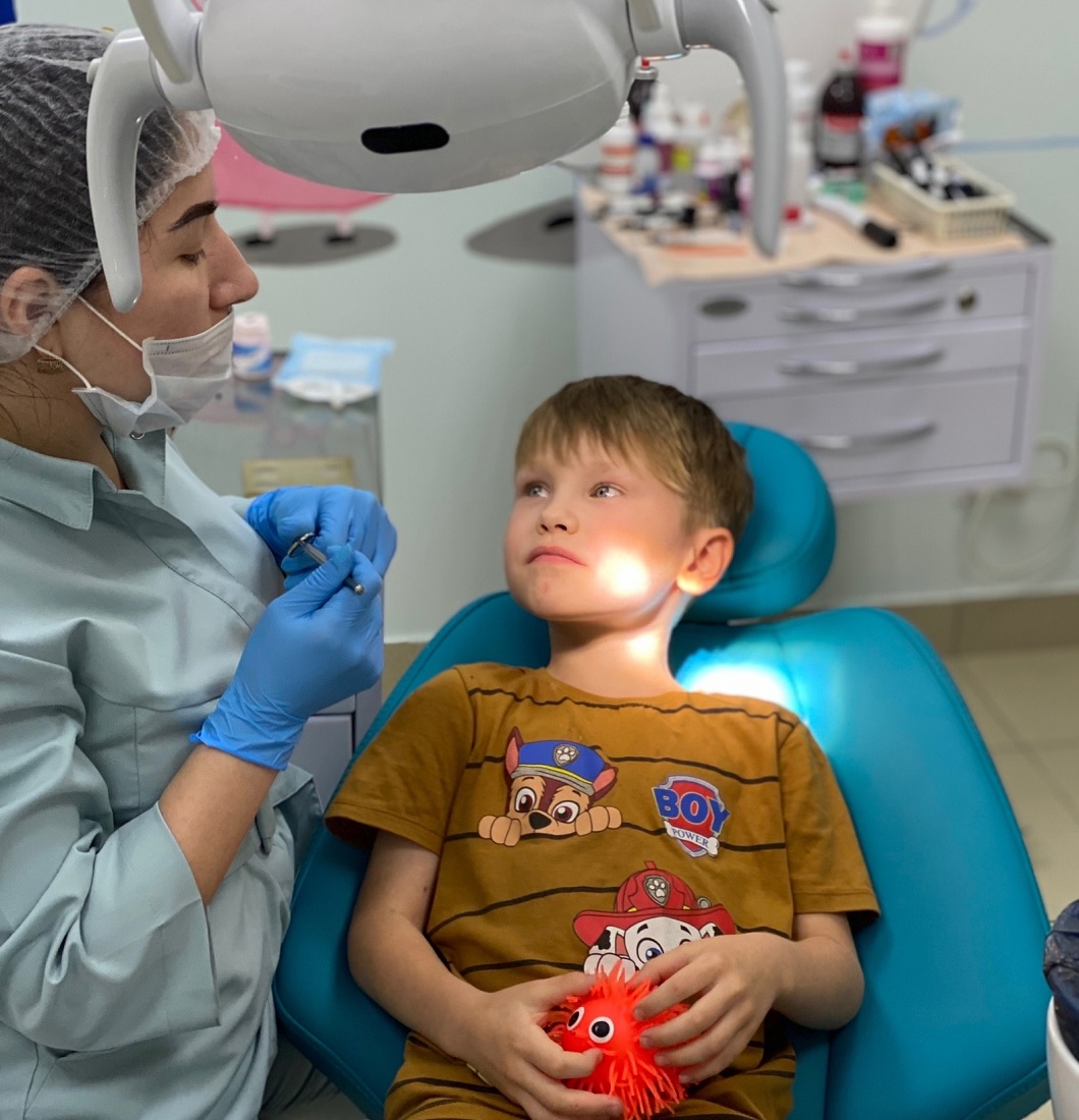 Ребенок на приеме у стоматолога в зубном кабинете